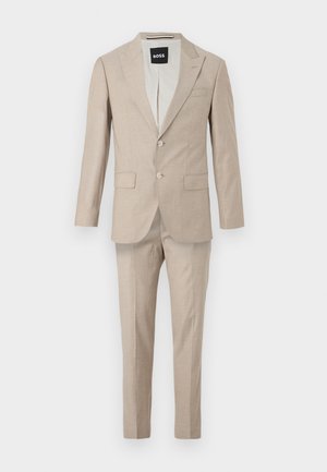 Costume beige composé d'une veste à deux boutons et à simple boutonnage ainsi que d'un pantalon assorti ; fabriqué en tissu léger.