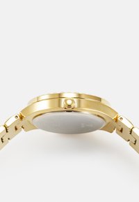 Goldfarbene Uhr mit einem polierten Metallarmband, runder Gehäuseform und strukturiertem Lünette. Verfügt über ein rundes, minimalistisches Zifferblatt mit einer sichtbaren Krone.