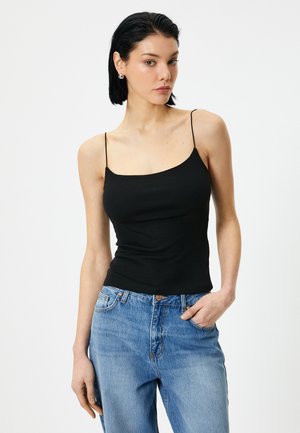 Zwarte stretch camisole met dunne bandjes en een ronde halslijn, gecombineerd met lichtblauwe high-waisted jeans. Glad materiaal met een getailleerde silhouet.
