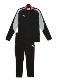 Tuta nera composta da una giacca con zip con accenti grigi e rossi, e pantaloni coordinati con strisce laterali rosse e logo bianco.