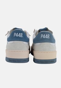 Sneakers bianchi in pelle con dettagli in tessuto e suede blu. Presentano una robusta suola beige. Testo sul tallone che recita: "Puoi andare a surfare più tardi."