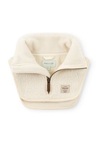 Beige Fleece-Pullover mit hohem Kragen, ausgestattet mit einem Frontreißverschluss, weichem Material und einem Etikett an der unteren Vorderseite, ideal zum Layering.