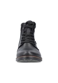 Botines de cuero negro con un collar acolchado, parte frontal con cordones y cremallera lateral. Presenta una suela de goma con un patrón texturizado.