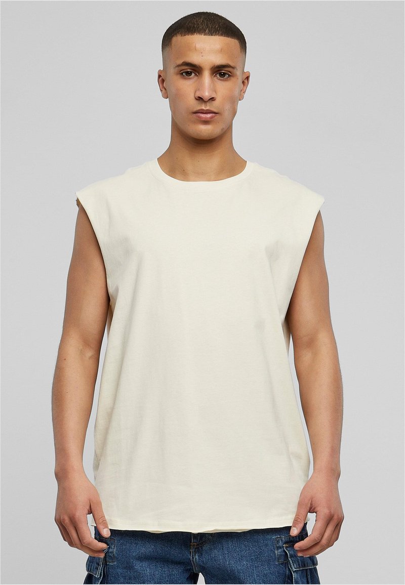 Sømløs beige bomulds t-shirt med rund hals, afslappet pasform og glat tekstur, båret med mørk denim cargo shorts.