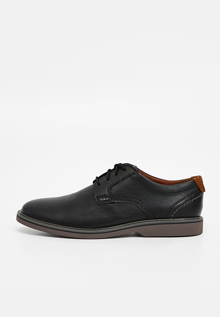Scarpe da uomo in pelle nera con una texture liscia, punta rotonda, dettaglio in pelle marrone sul tallone e design tradizionale con lacci.