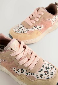 Sneakers med en övre del av blandad brun och rosa mocka, med ett vitt och fläckigt textilmönster, kompletterade med plana rosa snören och texturerade sulor.