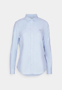 Himmelblaues Langarmshirt aus Baumwollmischung, klassischer Kragen, durchgehende Knopfleiste, abgerundeter Saum, mit einem kleinen gestickten Logo auf der Brust.