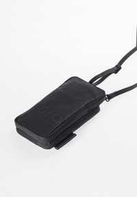 Black compact bag made of textured leather with a zipper closure and an adjustable strap. Features a debossed logo on the front.
