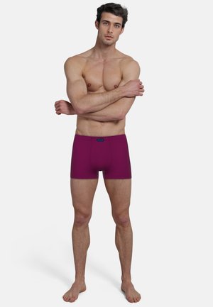 Lila Boxershorts aus weichem, dehnbarem Material, mit einer engen Passform und ohne sichtbare Nähte. Der Bund hat eine einfarbige Gestaltung mit einem kleinen Logo.
