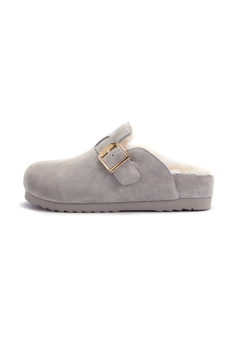 Zoccolo in suede grigio con interno peloso e dettaglio della fibbia dorata. Presenta una punta arrotondata e una suola in gomma testurizzata.