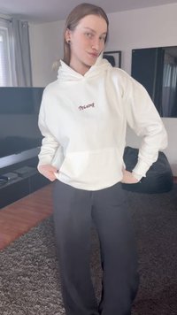 White hooded sweatshirt with "PEGADOR" in dark red text on the chest, paired with dark, loose-fitting pants, set against a neutral background.