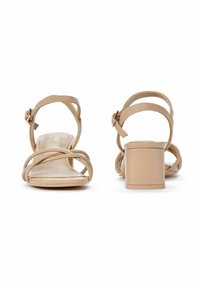 Beżowe sandały na obcasie z paskami, z blokowym obcasem, gładką skórzaną fakturą oraz regulowanym paskiem wokół kostki z detalem złotej klamry.