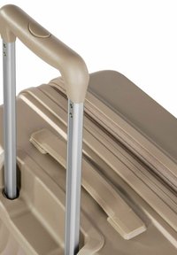Brown suitcase with a textured finish, extendable silver handle, and a side handle for easy carrying. Zipper detail along the edge.