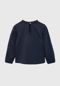 Tummansininen pitkähihaine paita, joka on valmistettu pehmeästä kankaasta. Paitassa on pyöreä kaula-aukko, kerätyt olkapäät ja avainaukko takana, jossa on napitus.