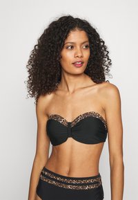 Juoda strapless bikini viršutinė dalis su leopardų rašto detalėmis viršutiniame krašte, derinama su aukšto liemens juoda bikini apatine dalimi.