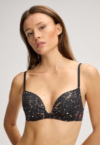 Czarny koronkowy biustonosz z głębokim dekoltem, z wzorzystym nadrukiem w odcieniach brązu, cienkimi regulowanymi ramiączkami oraz subtelnym logo.