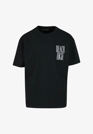 Musta puuvillapaita, jossa on pyöreä kaula-aukko, lyhyet hihat ja vasemmassa rinnan kohdassa valkoinen "REACH HIGH" -painatus.