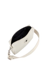 Borsa in pelle color crema con forma rettangolare, chiusura con zip, foderatura in tessuto e tracolla removibile. Presenta un accento in metallo a forma di logo circolare.
