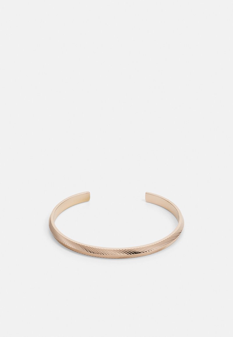 Gold-tone metal cuff bracelet with a textured, diagonal line pattern and smooth edges. Open design for adjustable fit.