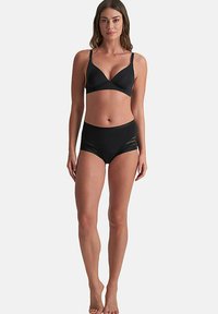 Zwarte lingerie set met een naadloze bh met verstelbare bandjes en hoge slips met doorschijnende paneelaccenten.