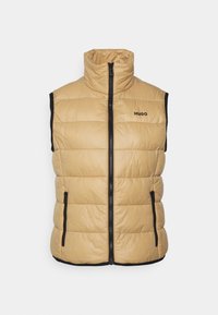 Polstrovaná bezrukávová vesta v světlém béžovém odstínu, s vysokým límcem, černými bočními panely, předním zipovým uzávěrem a nenápadným logem na hrudi.