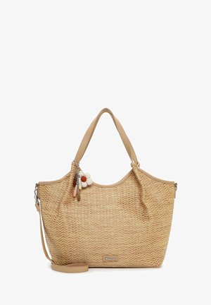 Beige geweven boodschappentas met dubbele handvatten, afneembare schouderriem en een bloemdecoratie die aan het handvat hangt.