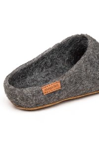 Szare filcowe kapcie o zaokrąglonym kształcie, z beżową skórzaną metką z napisem "magicfelt". Miękka tekstura i cienka, naturalna podeszwa.