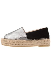 Metallic silver och svart espadrillo med en flätad jutesula. Har en rund tå och slip-on design. Mjuk textur och minimal detaljer.