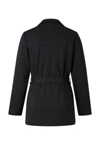 Veste noire à manches longues et taille ceinturée. Texture lisse, col structuré, design minimaliste et coupe légèrement cintrée.