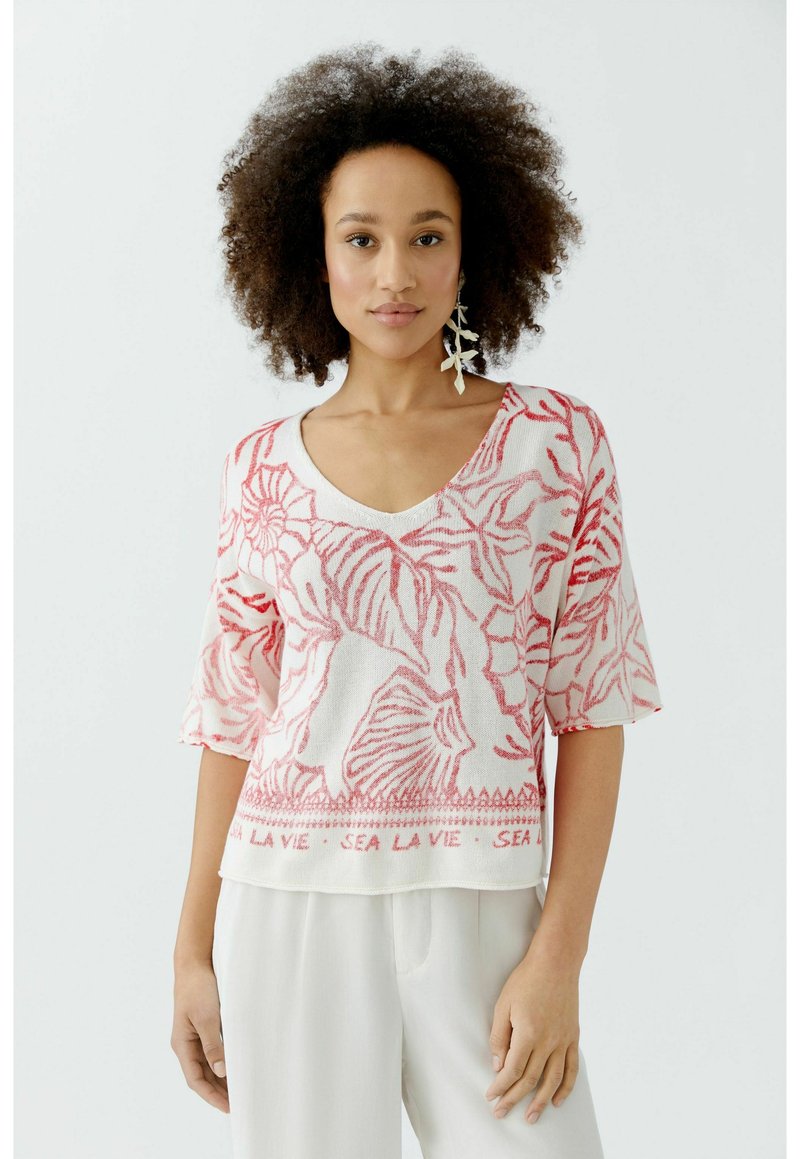 Roze en witte trui met korte mouwen, met bloemenprint en V-halslijn, met de tekst "SEA LA VIE" langs de onderrand.