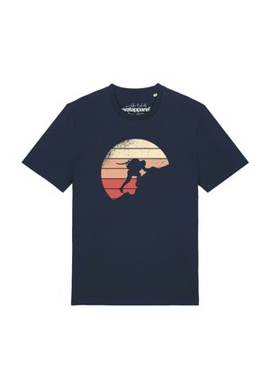 T-shirt bleu marine avec un graphisme d'une personne qui fait de la randonnée en montée devant un fond circulaire représentant un coucher de soleil dans des tons beige, orange et rouge.