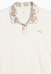 Μπεζ πόλο μπλούζα με γιακά σε φλοράλ σχέδιο, κεντημένο λογότυπο και κουμπωτό μανίκι. Κατασκευασμένη από απαλό ύφασμα με ελαφριά υφή.