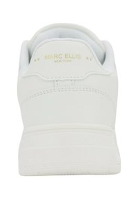 Sneakers bianchi con tomaia in pelle liscia, colletto arrotondato e marchio impresso in oro sul tallone. Suola piatta con un minimo dettaglio di battistrada.