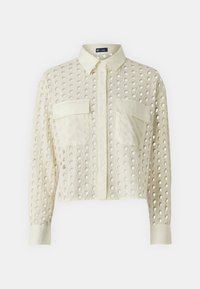 Long-sleeve, cropped shirt in light cream fabric with circular cutouts, featuring a pointed collar and two front pockets.