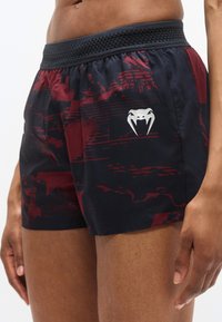Shorts de sport pour hommes avec un motif géométrique noir et bordeaux, une ceinture en maille et un logo argenté sur la cuisse.