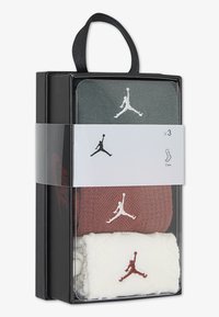Tre paia di calze crew Jordan in verde, marrone e bianco. Ognuna ha un logo Jordan a contrasto ricamato sul davanti. Imballate in una scatola nera.