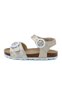 Sandales en cuir beige avec des motifs de marguerites blanches, deux sangles réglables avec des boucles en forme de fleur, et une semelle intérieure en liège. Semelle en caoutchouc blanche.
