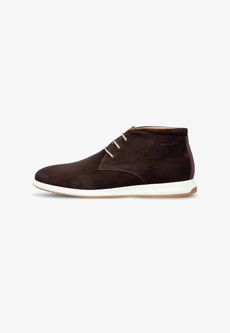 Bottine chukka en daim marron avec lacets crème et semelle blanche, hauteur basse à la cheville et bout arrondi, vue de profil sur fond blanc.