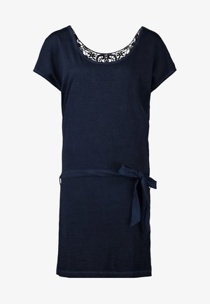 Robe bleu marine à manches courtes avec une taille cintrée, associée à des collants noirs et des bottines, complétée par un sac bandoulière noir.