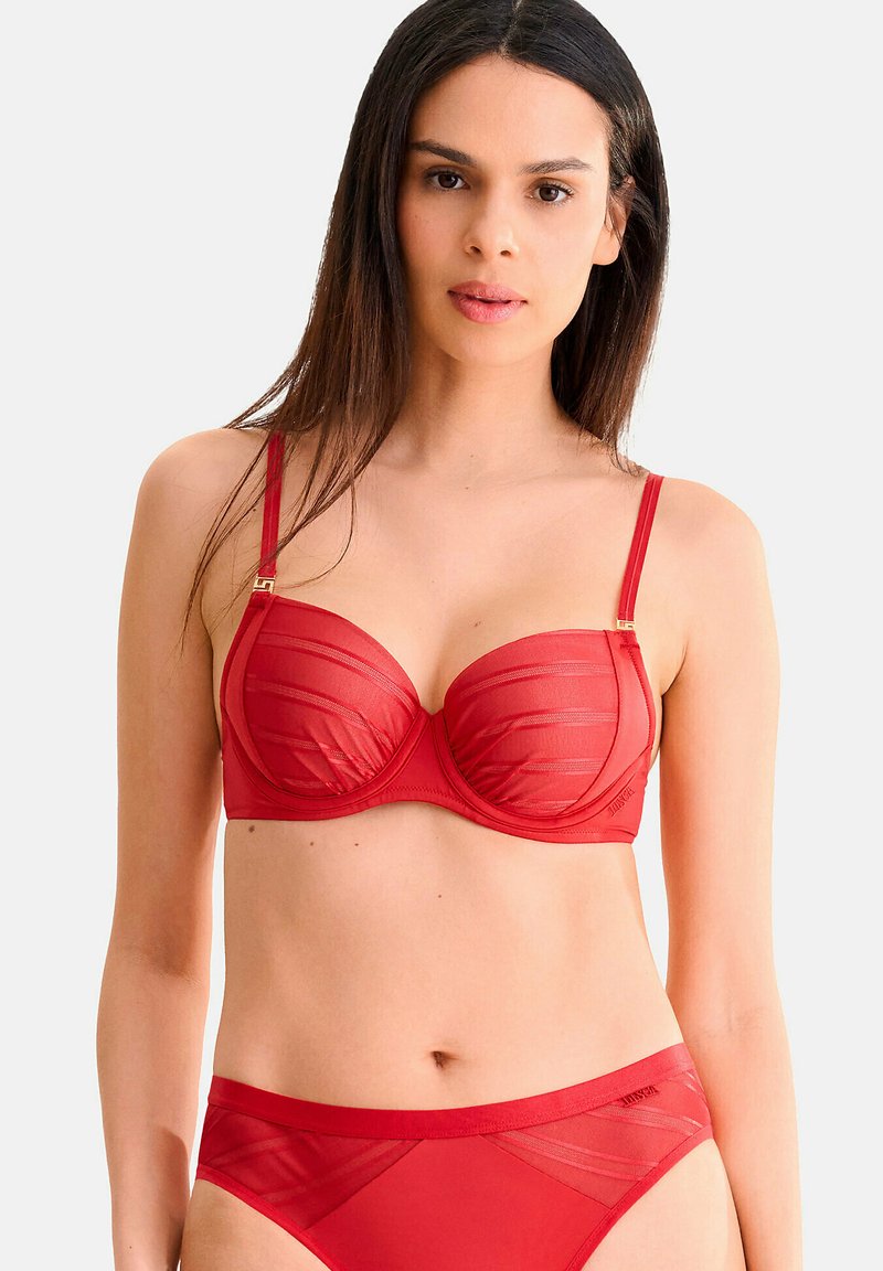 Ensemble de lingerie rouge comprenant des bonnets en mesh transparent avec des rayures horizontales, un design à armatures rembourrées, des bretelles réglables et un bas taille haute assorti.