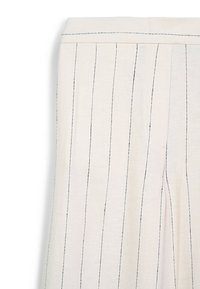 Un pantalon beige clair avec des rayures verticales noires, fabriqué en tissu tissé avec une texture subtile et une taille ajustée.