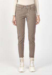 Brown corduroy pants with a slim fit, featuring front pockets and a button closure. Paired with white high-top sneakers. Plain background.