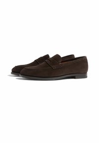 Brune ruskind loafers med en stikning ved tåen, et bånd over vristen og en flad gummisål. Glat tekstur og rund facon.