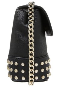 Czarna torebka o teksturowanej powierzchni i okrągłym kształcie, wyposażona w złoty łańcuszek jako pasek oraz ozdobiona srebrnymi ćwiekami u podstawy. Górna klapka zamykająca.