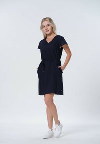 Marineblå kortärmad klänning med V-hals, dragsko i midjan och två sidofickor. Tillverkad av mjukt tyg, har en avslappnad design.