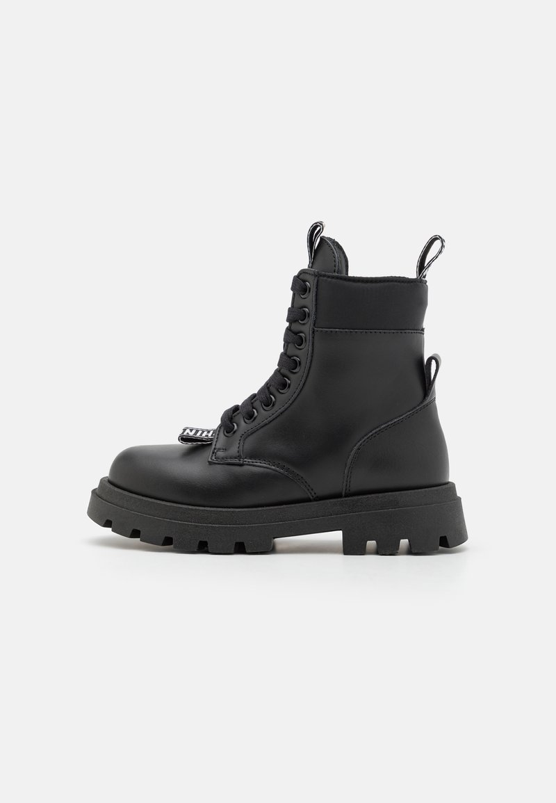 Bottes chevilles en cuir noir avec un bout arrondi, un laçage à l'avant et une semelle robuste. Comprend deux tirettes et une sangle avec logo sur le côté.