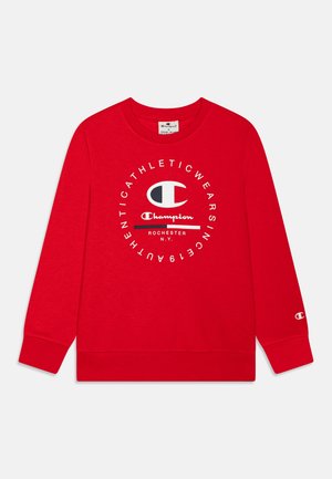 Sudadera roja hecha de tela suave, con un cuello redondo, mangas largas y una impresión central del logo con "Champion" y "Rochester, N.Y."