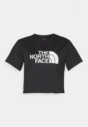 Črna kratka majica iz bombaža, ki ima spredaj bel logotip s ukrivljenimi akcenti in besedilom "THE NORTH FACE". Kratke rokave, okroglo izrezan ovratnik.