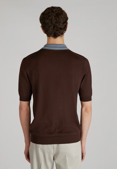 Camisa polo de manga corta marrón con cuello azul claro, hecha de tejido de punto, que presenta un dobladillo acanalado y detalles en los hombros.