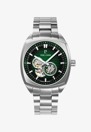 Montre-bracelet carrée en métal argenté avec cadran rayé vert, engrenages visibles, deux sous-cadrans, index argentés et bracelet à maillons en métal.